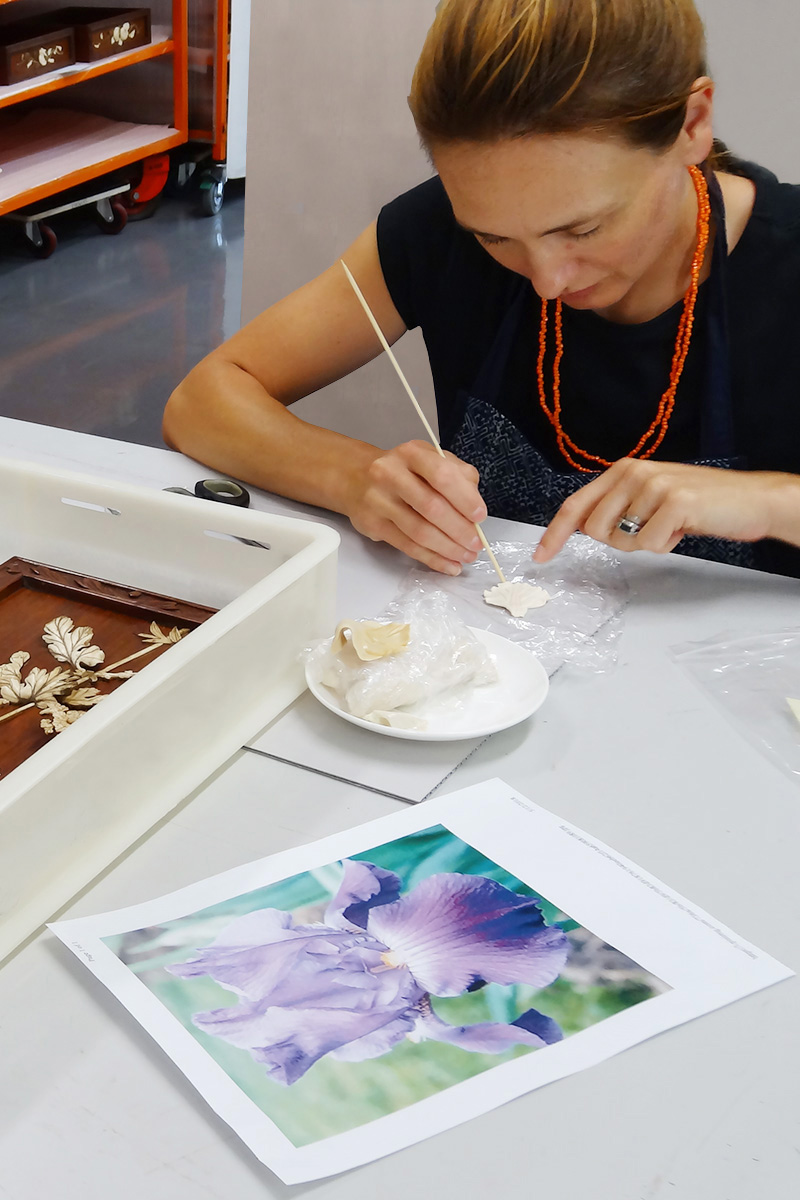 Photograph of conservator shaping new flower