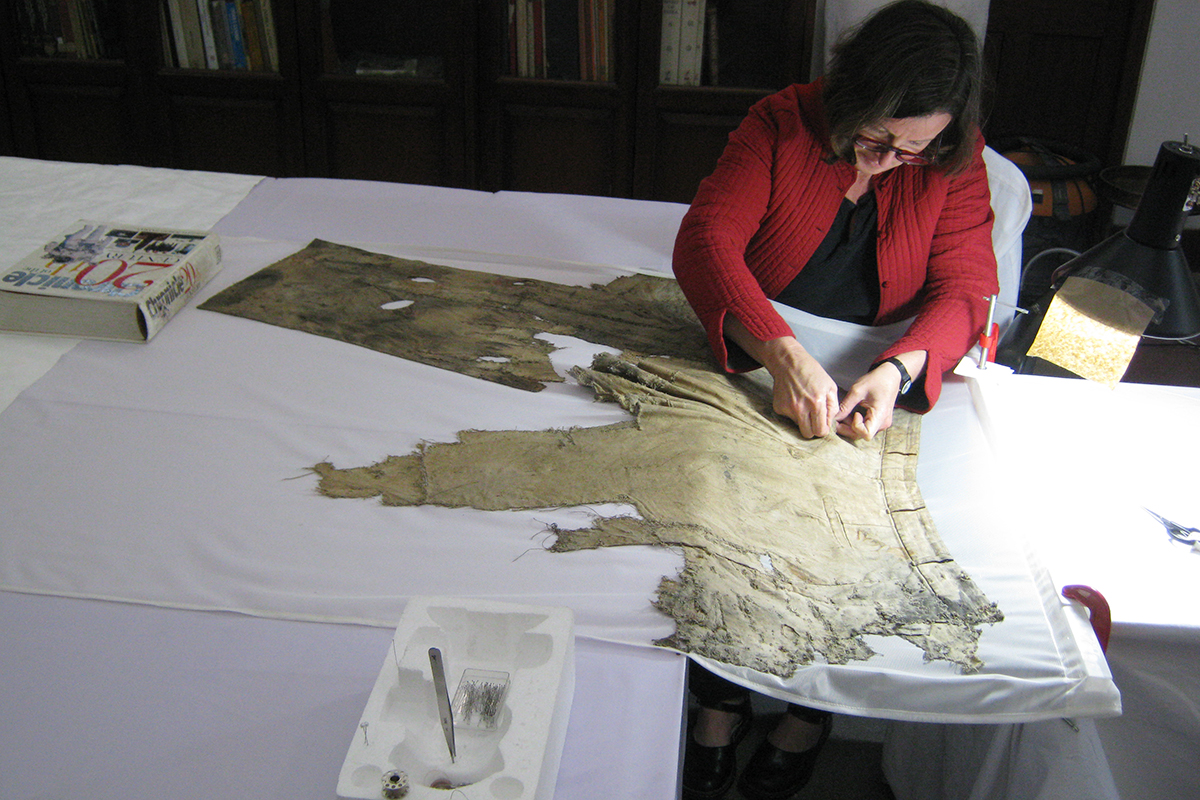 Conservator hand stitching trousers