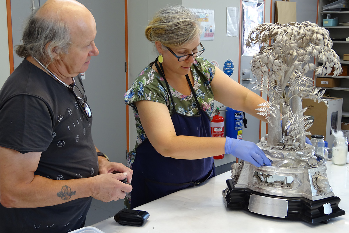 Silversmith and conservator reassembling silver trophy