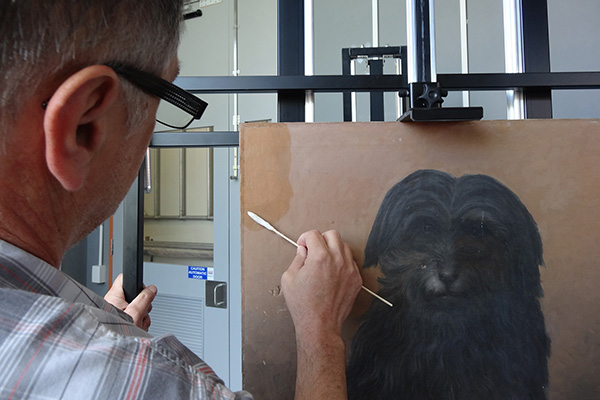 Conservator cleaning painting