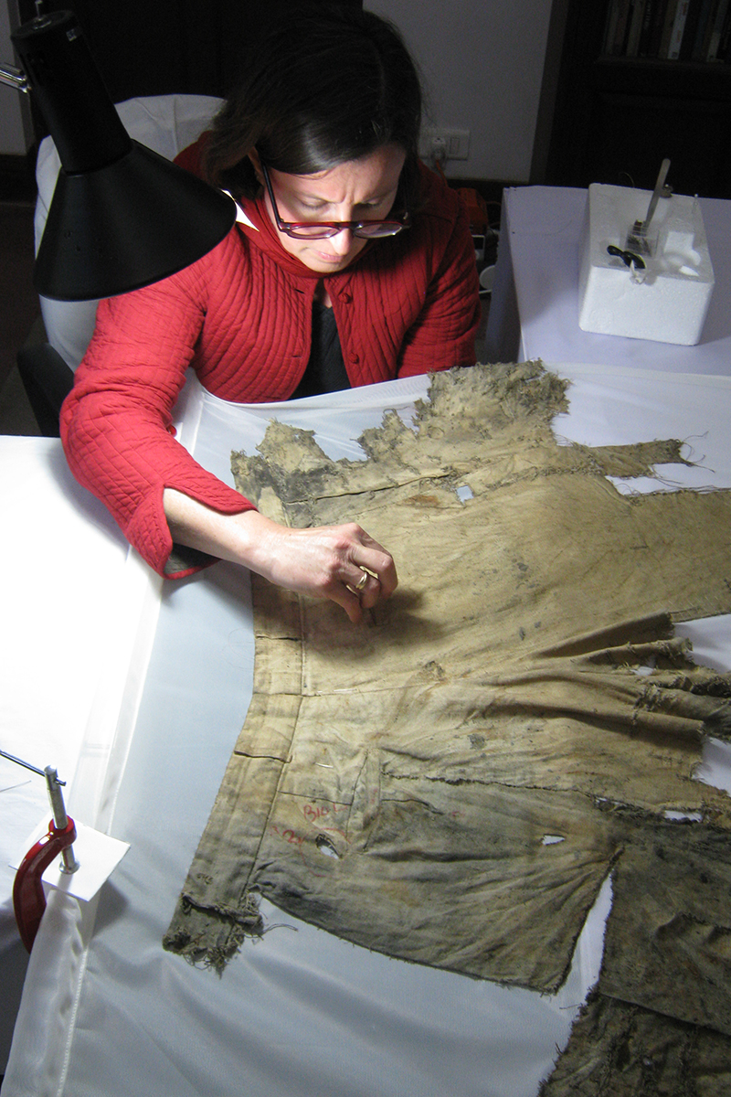 Conservator hand stitching trousers