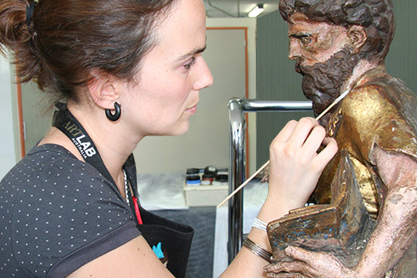 Conservator cleaning sculpture