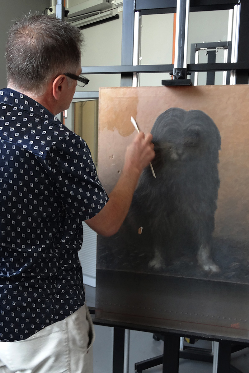 Conservator cleaning paintings