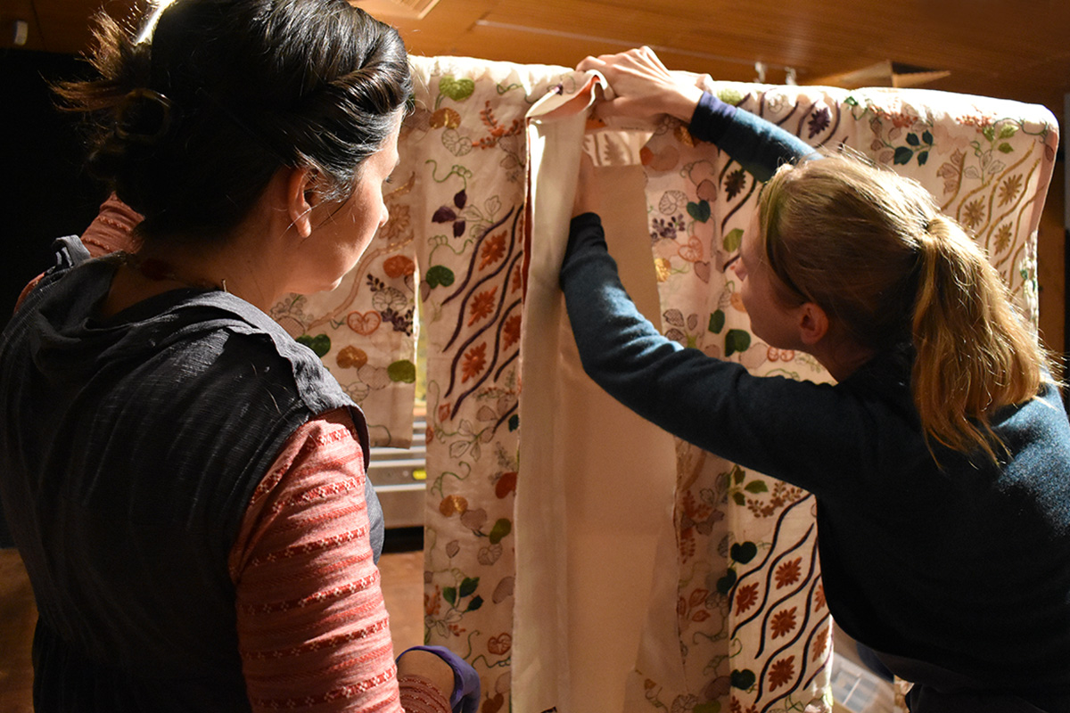 Conservators installing kimono in exhibition