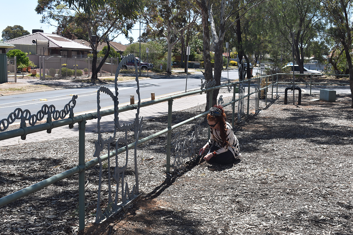 Conservator examining playground fence