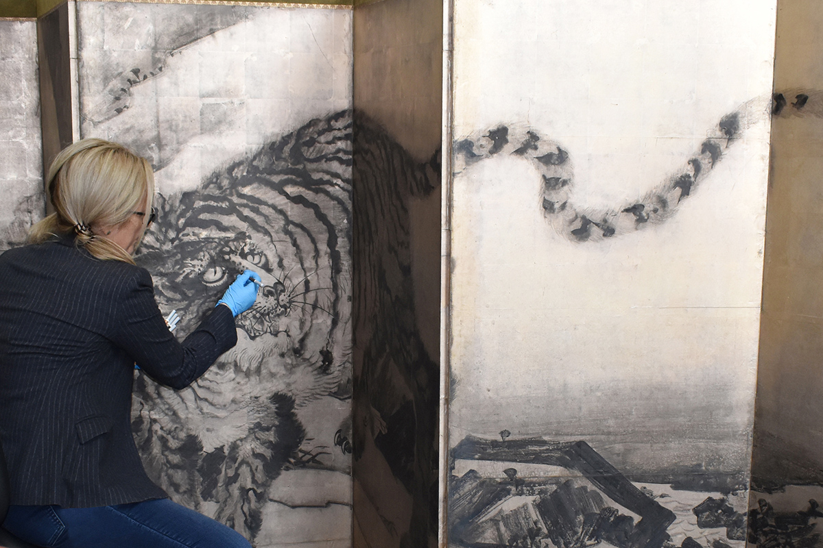 Paper conservator working on Japanese screen