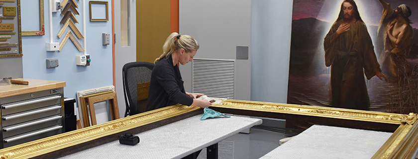 Conservator working on frame