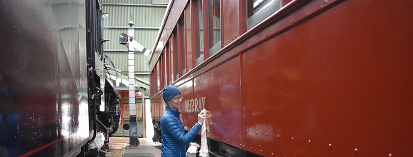 Conservator cleaning railway carriage