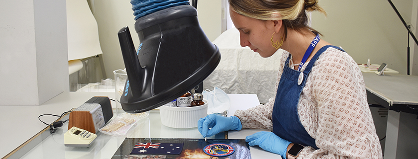 Conservator working on badges