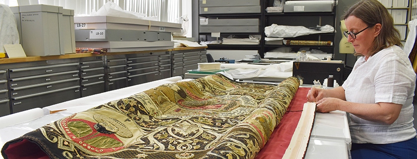 Textiles conservator hand sewing wall hanging