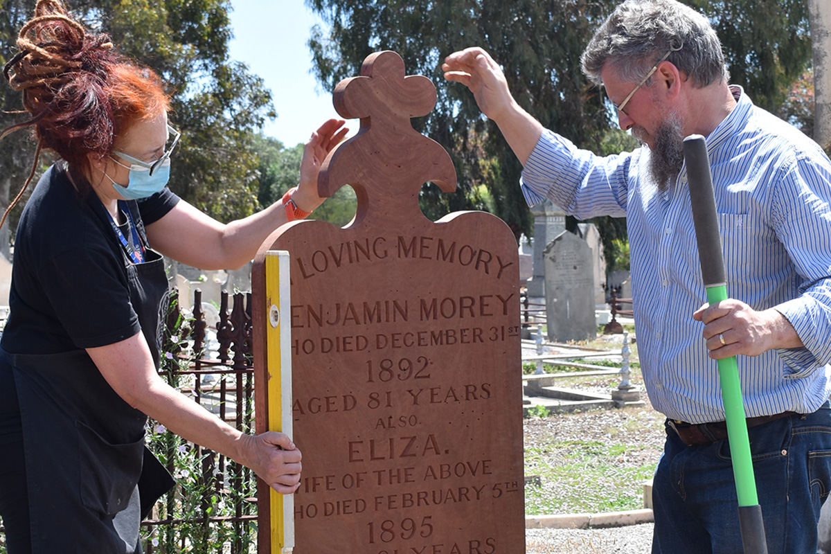 Conservators installing grave marker