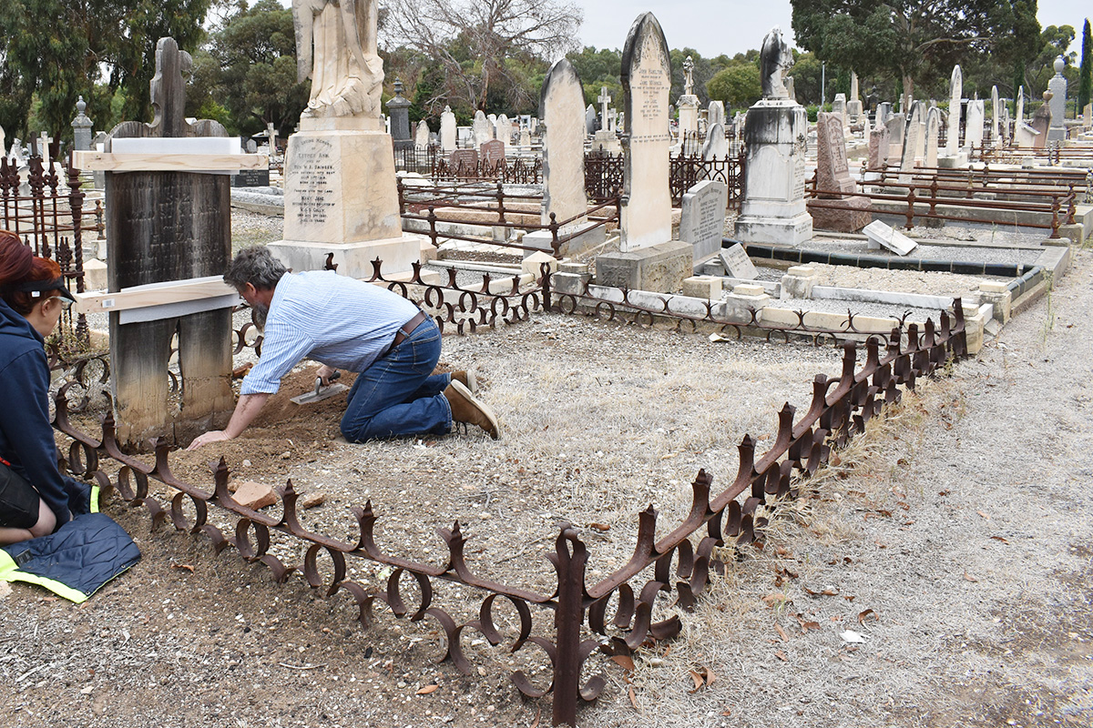 Conservators removing grave marker