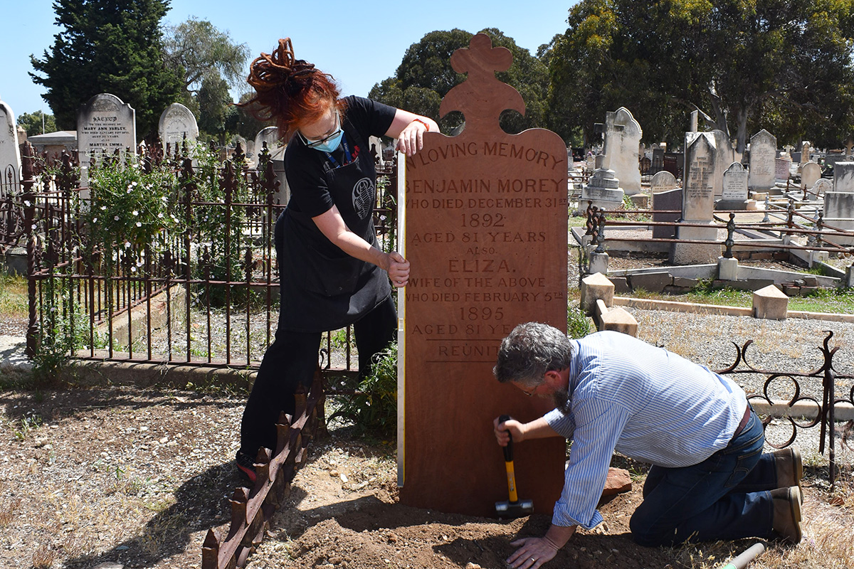 Conservators installing new grave marker