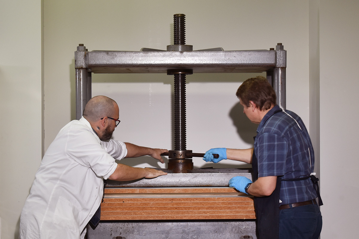 Conservators pressing paper item
