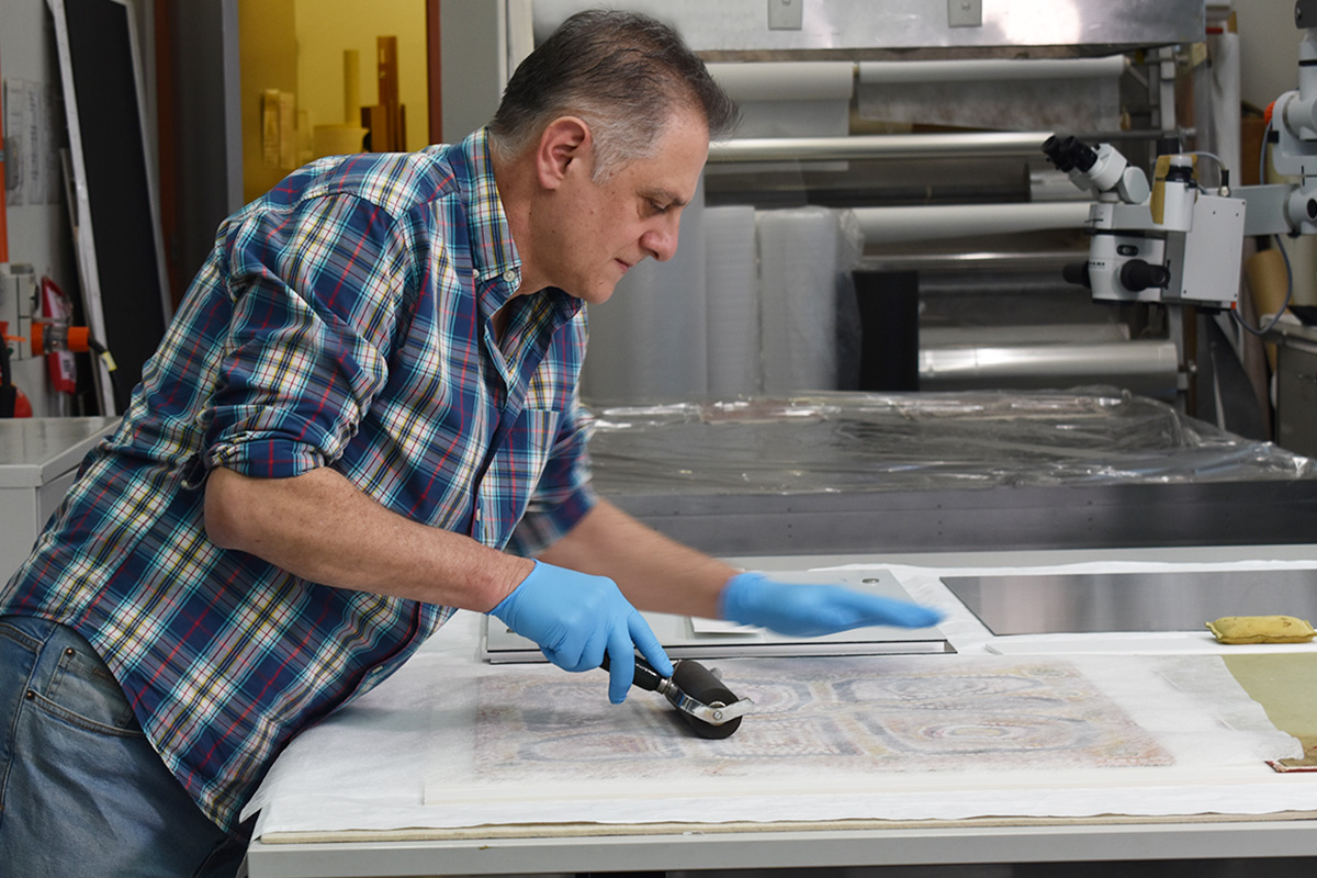 Conservator rolling a painting