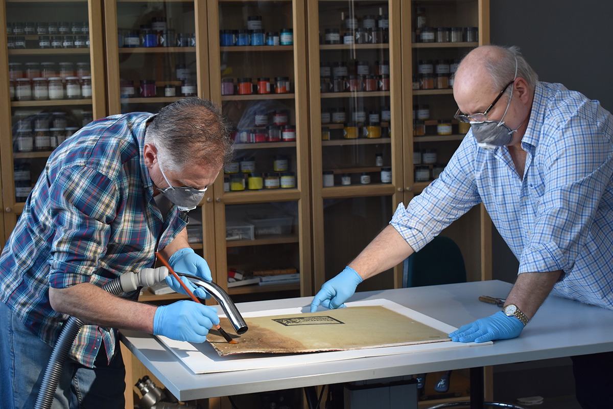 Conservator cleaning a painting