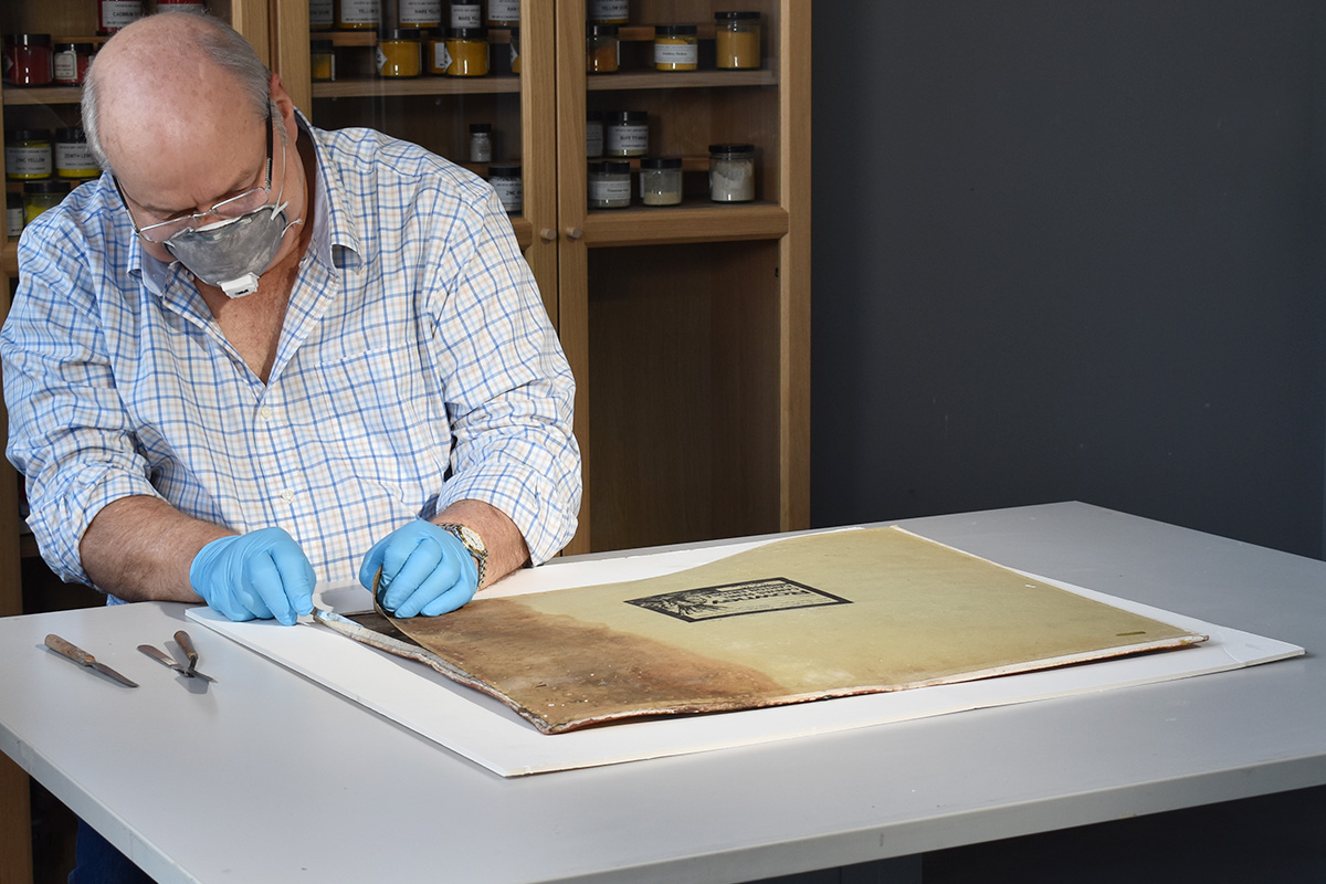 Conservator examining back of painting