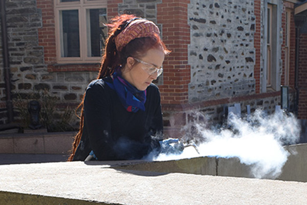 Conservator steam cleaning sculpture