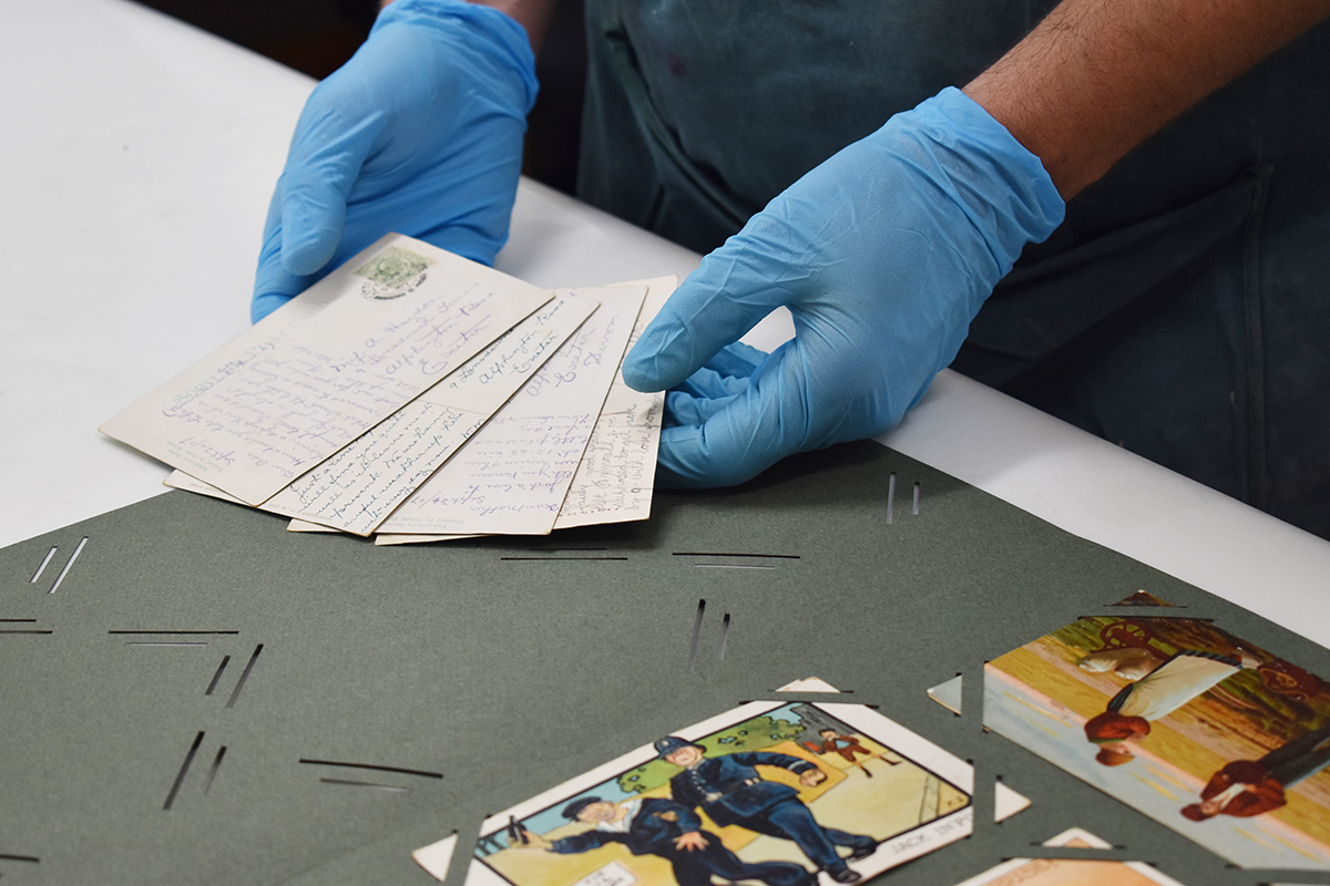 Postcards being arranged in to new album