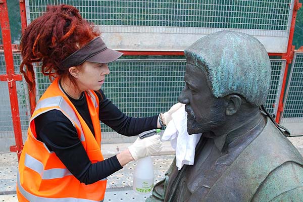 Conservator cleaning bronze sculpture