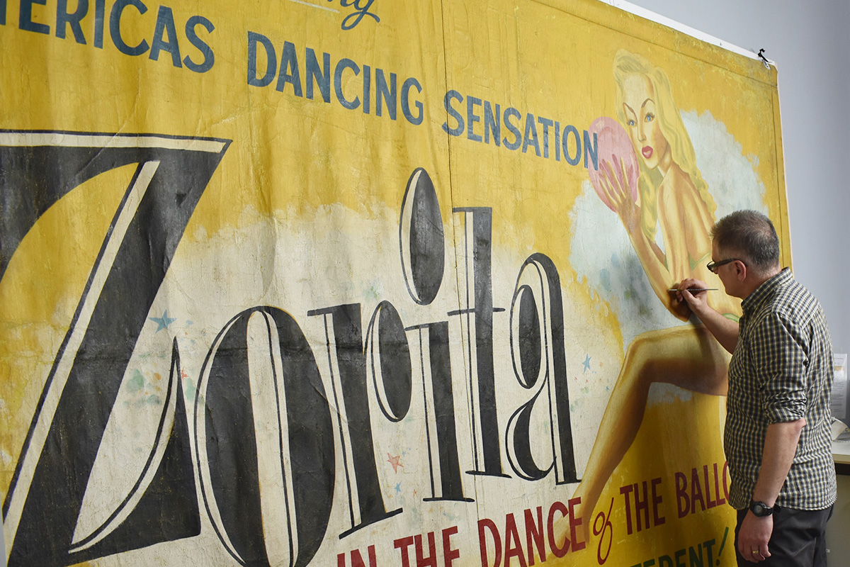 Conservator working on banner